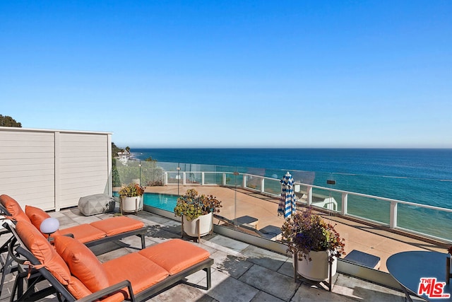 view of patio featuring a balcony and a water view