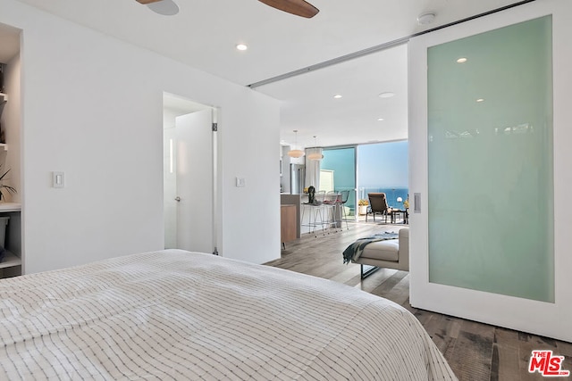 bedroom with wood-type flooring and expansive windows