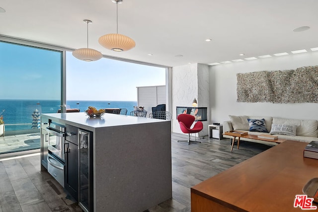 kitchen featuring a water view, dark hardwood / wood-style floors, hanging light fixtures, and a center island