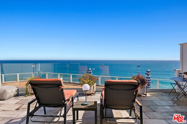 view of patio / terrace with a water view and a balcony