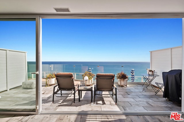 sunroom featuring a water view