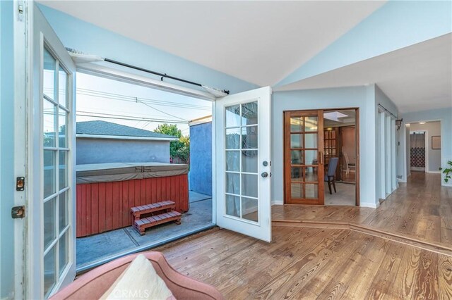 entryway featuring vaulted ceiling, french doors, wood finished floors, and baseboards