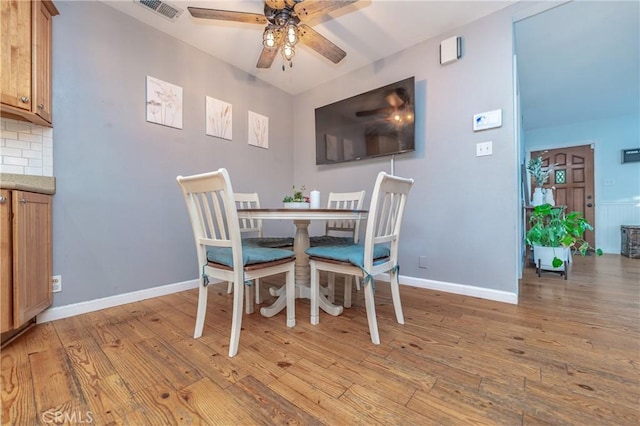 dining room with light wood-type flooring, ceiling fan, visible vents, and baseboards