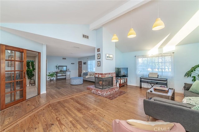 living area featuring high vaulted ceiling, beam ceiling, wood finished floors, and visible vents