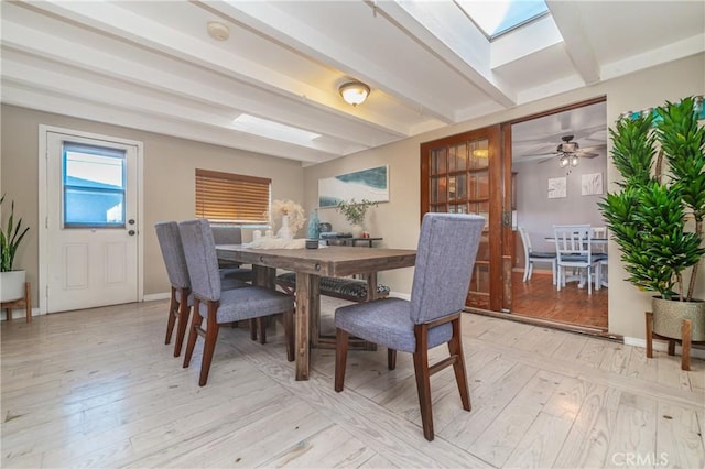 dining room with light wood-type flooring, beam ceiling, and baseboards