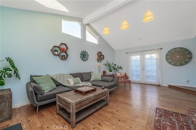 living area featuring high vaulted ceiling, a skylight, beam ceiling, and light wood-style flooring