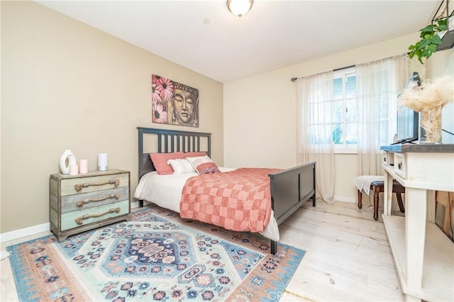 bedroom featuring baseboards and wood finished floors