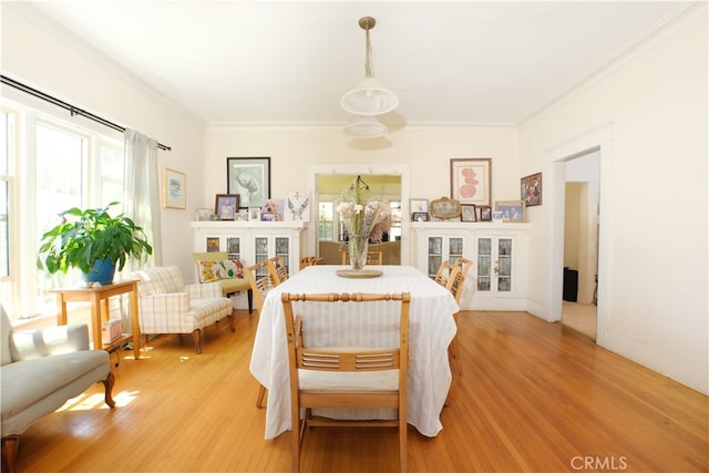 dining space with hardwood / wood-style floors and ornamental molding