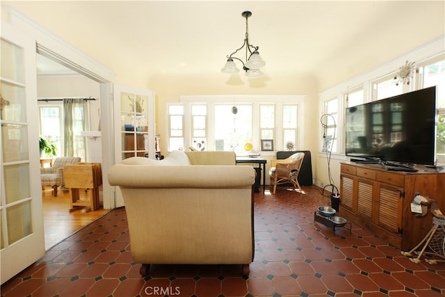 living room with dark tile patterned floors and a notable chandelier