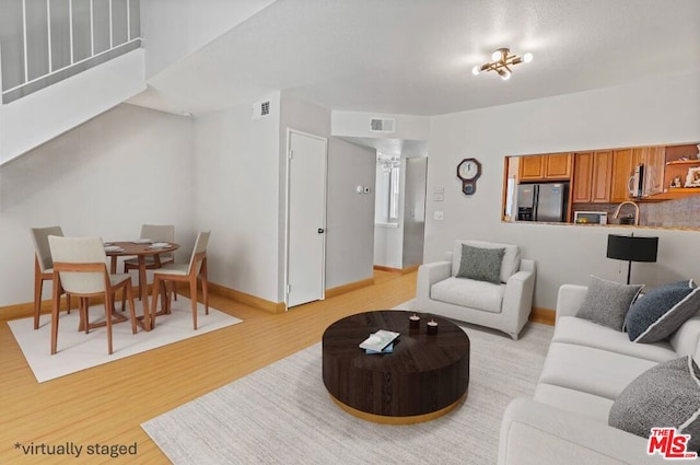 living room with a chandelier and light hardwood / wood-style flooring