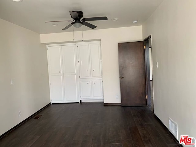 unfurnished bedroom with ceiling fan, a closet, and dark hardwood / wood-style floors