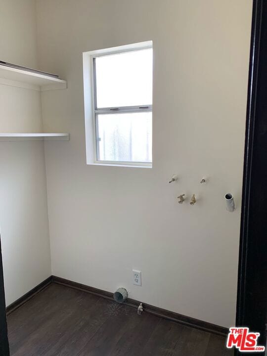 clothes washing area featuring dark wood-type flooring