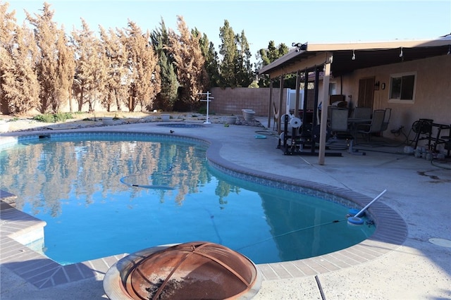 view of swimming pool featuring a patio area and an outdoor fire pit