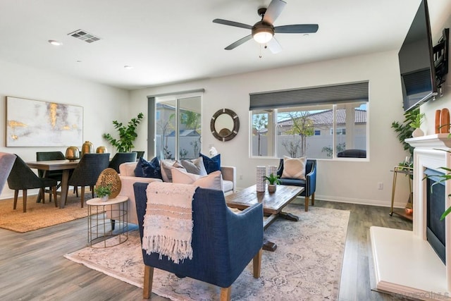 living room with wood-type flooring and ceiling fan