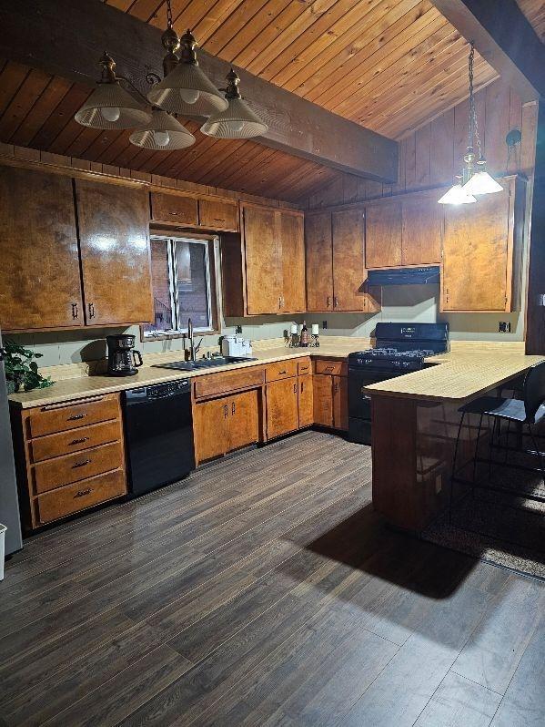 kitchen with hanging light fixtures, dark wood-type flooring, and black appliances