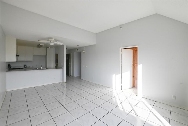 unfurnished living room featuring ceiling fan, lofted ceiling, sink, and light tile patterned floors