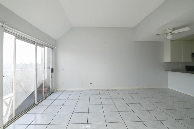 tiled empty room with vaulted ceiling and ceiling fan