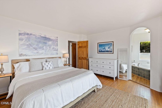 bedroom featuring ensuite bathroom and light hardwood / wood-style floors