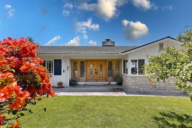 back of property featuring covered porch and a lawn