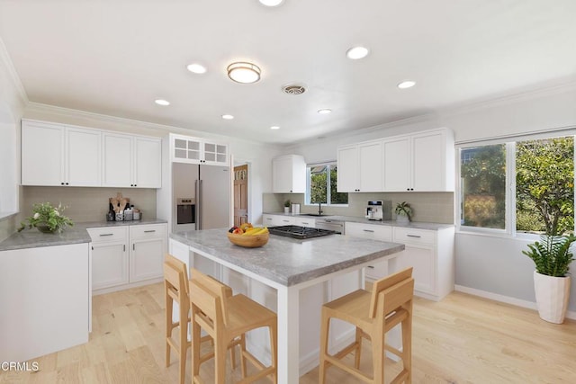 2335 Whitney Ave, Summerland, CA 93067 - kitchen featuring visible vents, ornamental molding, refrigerator with ice dispenser, and a breakfast bar area