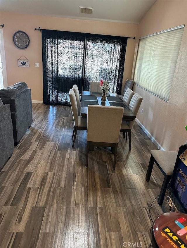 dining room with dark hardwood / wood-style floors and vaulted ceiling