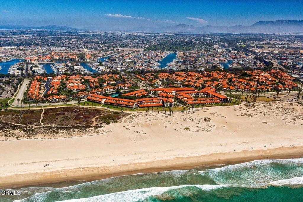 birds eye view of property featuring a view of the beach and a water and mountain view