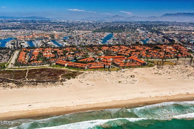 birds eye view of property featuring a view of the beach and a water and mountain view