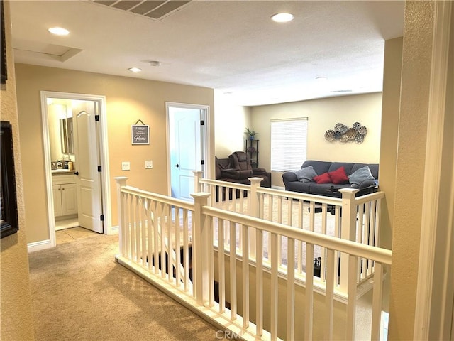 hallway with light colored carpet