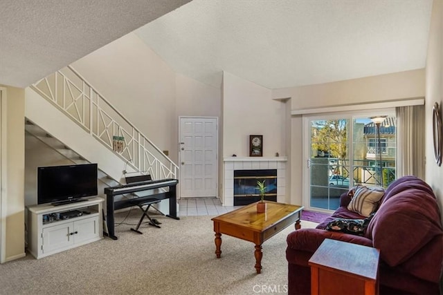 carpeted living room featuring a textured ceiling and a tiled fireplace