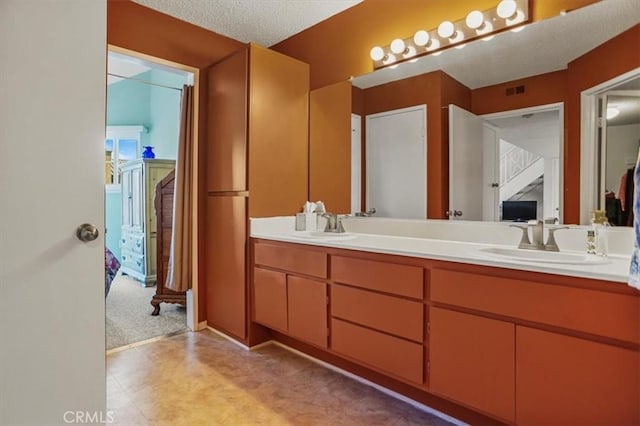 bathroom featuring a textured ceiling and vanity