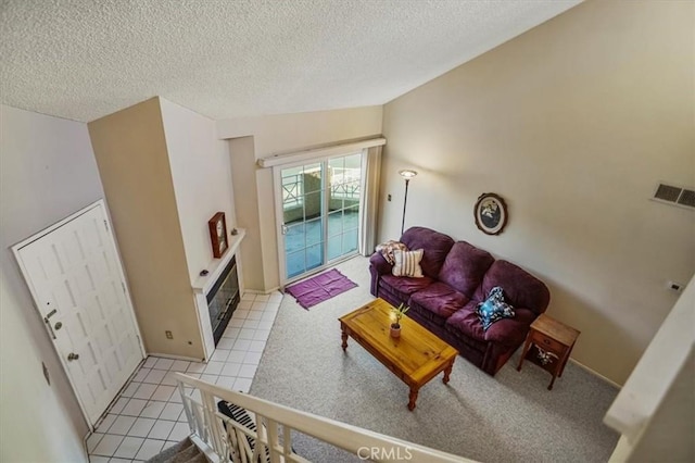 tiled living room featuring vaulted ceiling, a fireplace, and a textured ceiling