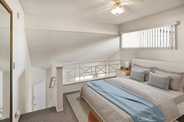 bedroom with a textured ceiling, ceiling fan, and multiple windows