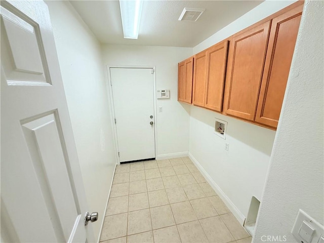 washroom with washer hookup, cabinets, and light tile patterned flooring