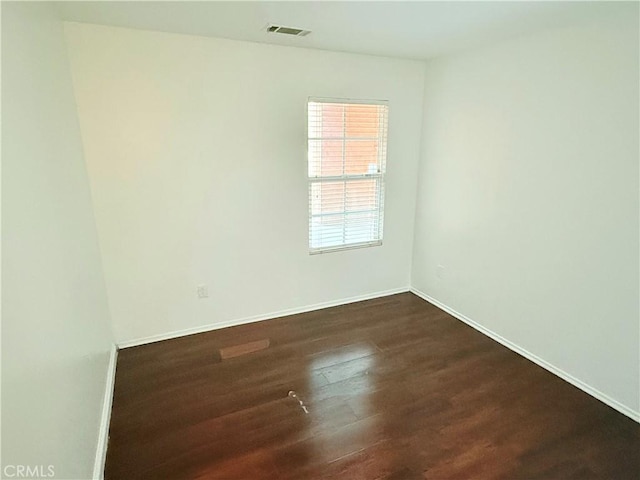 unfurnished room with dark wood-type flooring