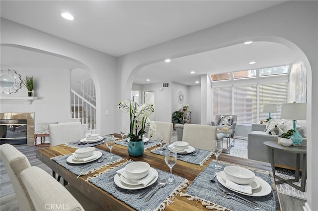 dining area with hardwood / wood-style flooring and a tile fireplace