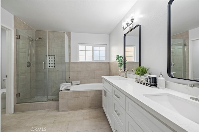 full bathroom with a stall shower, toilet, a sink, and a garden tub