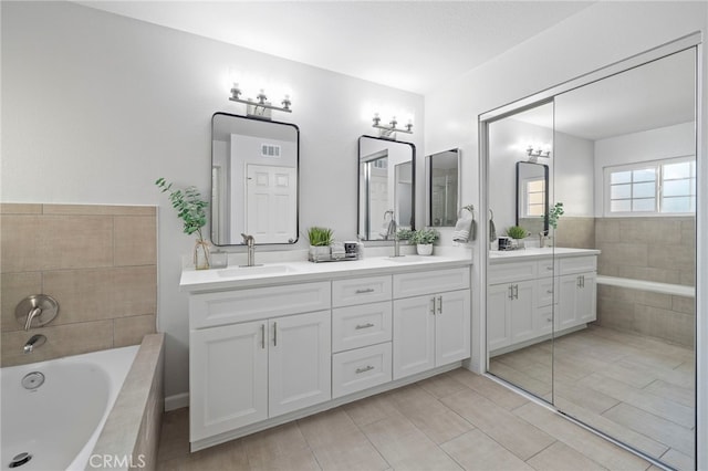 bathroom featuring vanity and tiled bath