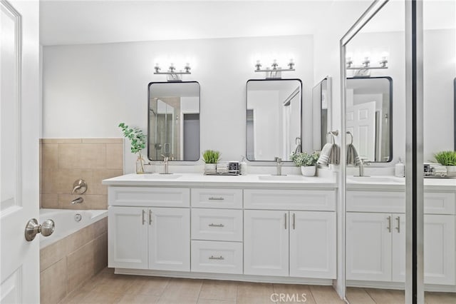 bathroom with vanity and tiled tub