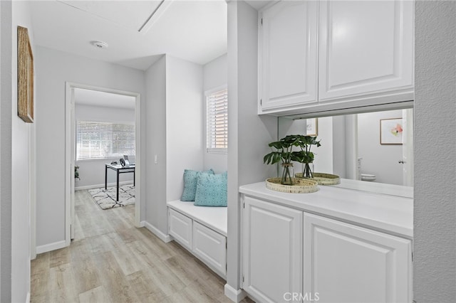 bar with plenty of natural light, baseboards, and light wood-style flooring