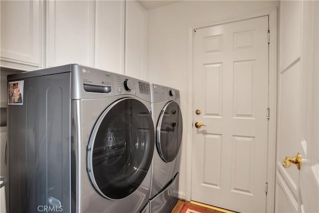 laundry area with washer and dryer and cabinets