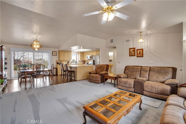 living room featuring ceiling fan, vaulted ceiling, and carpet