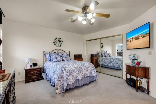 carpeted bedroom featuring ceiling fan and a closet