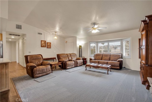 living room with ceiling fan, light colored carpet, and lofted ceiling