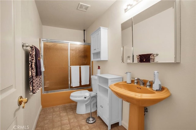 bathroom featuring toilet and enclosed tub / shower combo