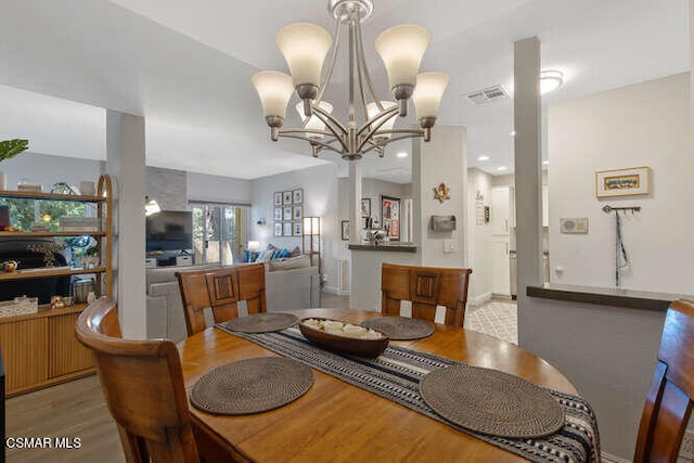 dining room with an inviting chandelier and light hardwood / wood-style flooring