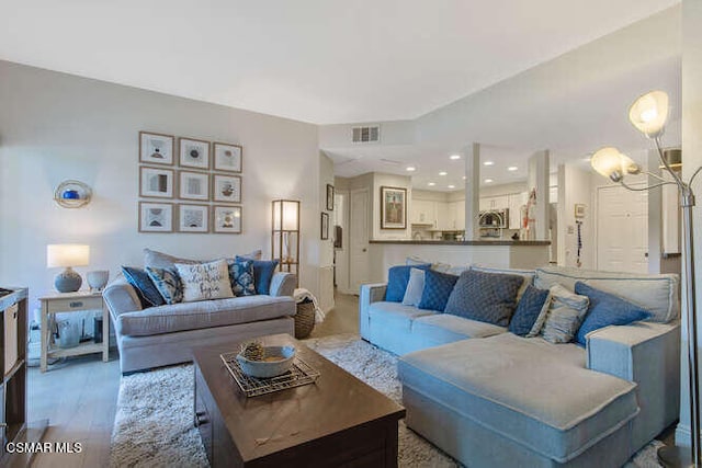 living room featuring an inviting chandelier and hardwood / wood-style flooring