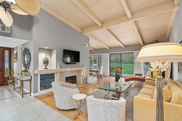 living room with wood ceiling, a fireplace, high vaulted ceiling, ceiling fan, and beam ceiling