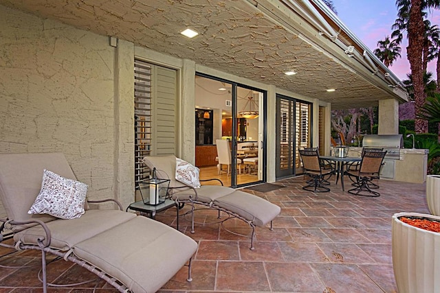 patio terrace at dusk featuring area for grilling