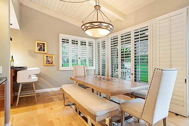 dining space with light hardwood / wood-style floors and beamed ceiling