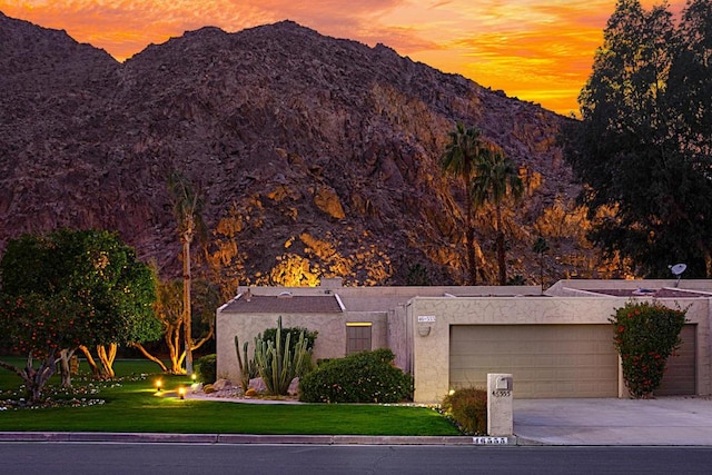 view of front of property with a mountain view, a yard, and a garage